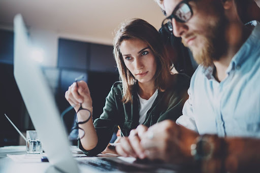 Two people working at a laptop