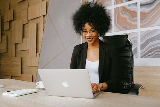 African woman staring at computer and smiling